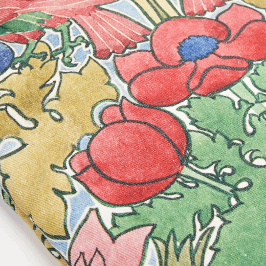Detail shot of an oven glove featuring a red and green botanical pattern.